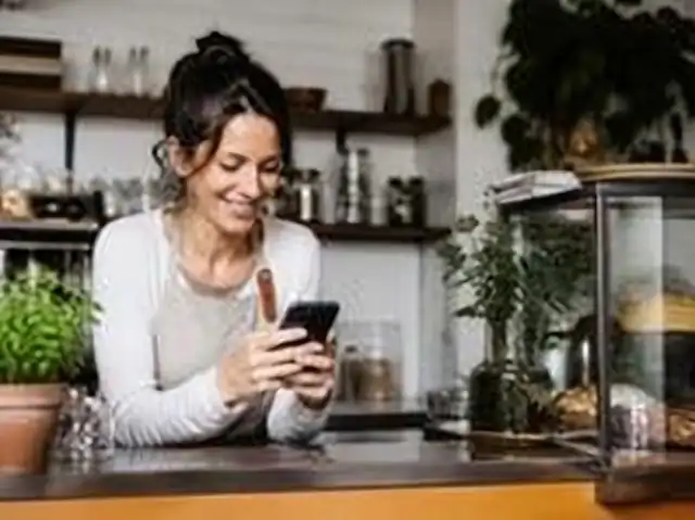 Café owner reading new Google reviews on her phone